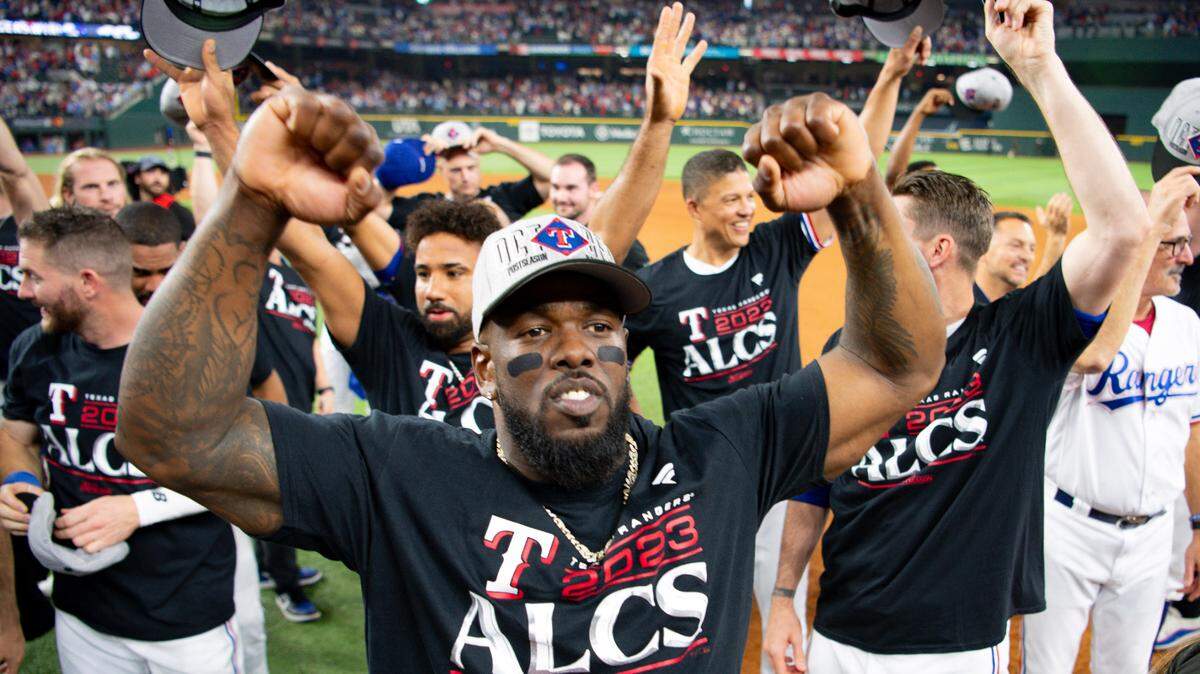 El jardinero de los Rangers Adolis García (centro) saluda a los aficionados en el Globe Life Field de Texas tras barrer a los Orioles en la Serie de División, el 10 de octubre de 2023.