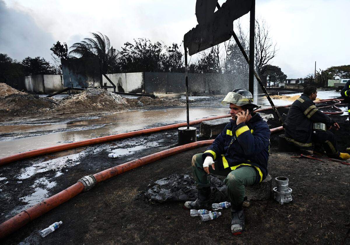 Los bomberos descansan en el lugar de un incendio mortal en una gran instalación de almacenamiento de petróleo en Matanzas, Cuba, el martes 9 de agosto de 2022. El incendio se desencadenó cuando un rayo golpeó uno de los ocho tanques de la instalación la noche del viernes 5 de agosto. (Yamil Lage, foto vía AP)