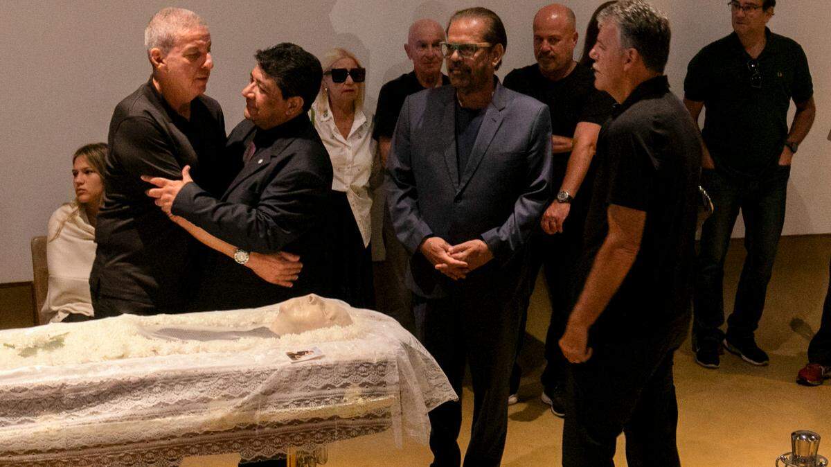 El presidente de la Confederación de Fútbol de Brasil Ednaldo Rodrigues (der.) abrasa a Mario César Zagallo, hijo del exentrenador y jugador de Brasil Mario Zagallo, durante el funeral en las instalaciones de la entidad, el domingo 7 de enero del 2023 en Río de Janeiro. 