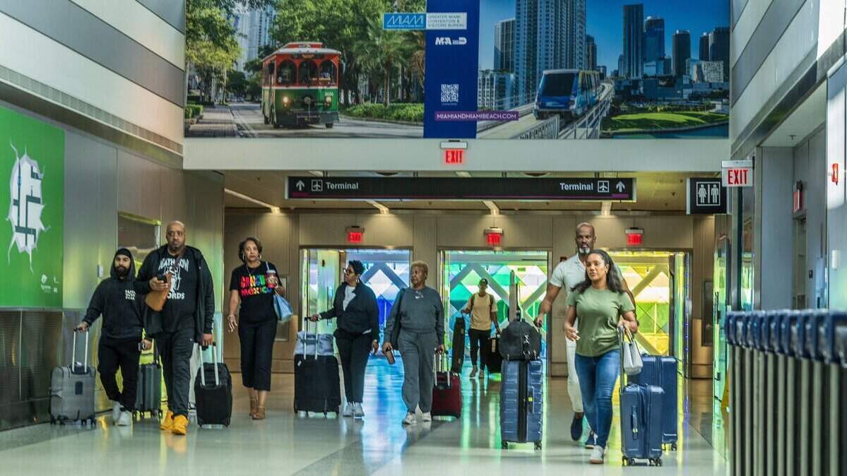 Passengers walked out of the terminal to take the train to the rental building, at Miami International Airport ahead of the Holidays in Miami, on Friday, November 21, 2025.