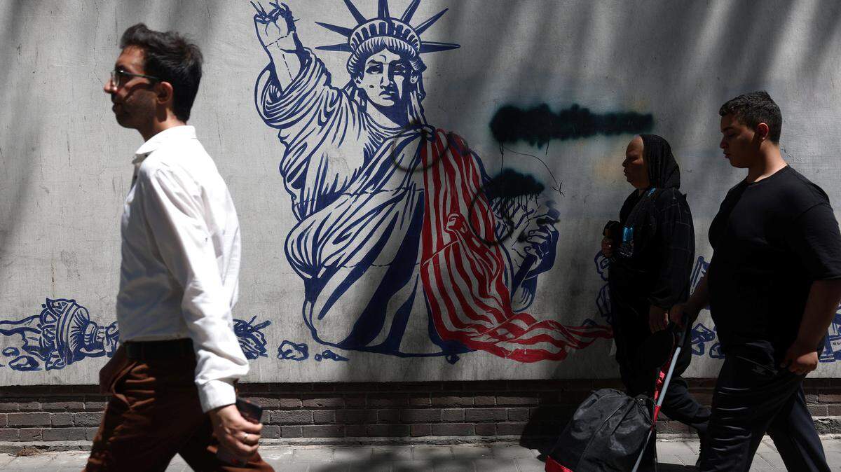 Varias personas pasan junto a un mural antiestadounidense en una calle de Teherán, Irán, el lunes 1 de junio de 2026.