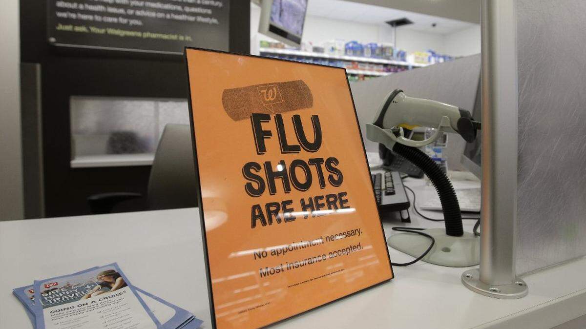 Un cartel permite informa a los clientes que pueden obtener una vacuna contra la gripe en una tienda Walgreens en Indianápolis.