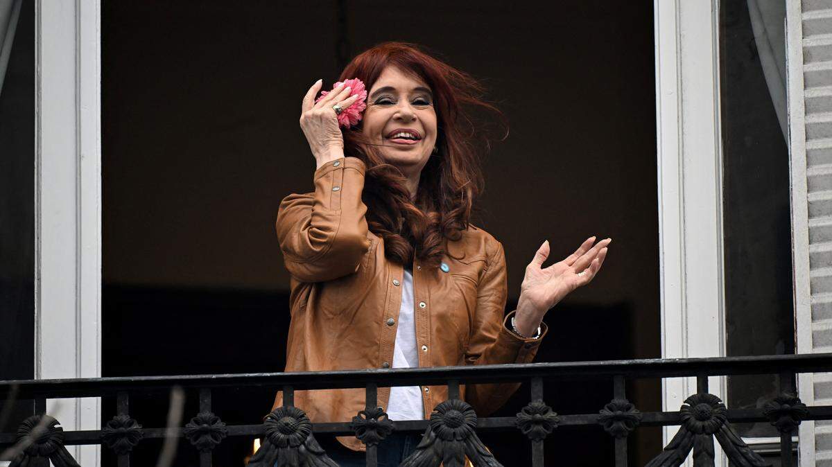Argentina's former President (2007-2015) and vice-president (2019-2023) Cristina Fernandez de Kirchner waves at supporters from the balcony of her residence where she is serving house arrest in Buenos Aires on September 20, 2025, on the 100th day of her arrest. The 72-year-old, who is serving a six-year sentence under house arrest after being convicted of "fraudulent administration" during her presidency, is allowed to receive limited visits, but she is expressly banned "from any behavior that could disturb the peace of the neighborhood and/or disturb the peaceful coexistence of its residents." (Photo by Luis ROBAYO / AFP) (Photo by LUIS ROBAYO/AFP via Getty Images)