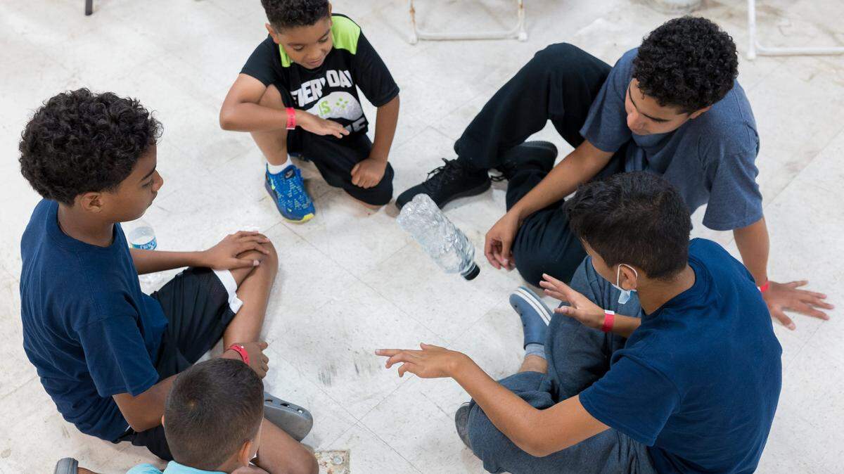 Niños migrantes juegan en el Centro de Bienvenida de Migrantes en el noreste de El Paso, Texas.