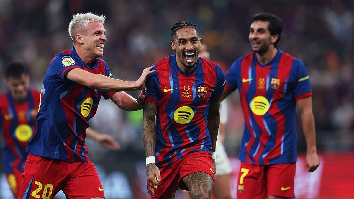 El jugador de Barcelona Raphinha (centro) celebra con su compañero de equipo Dani Olmo tras anotar un gol ante el Real Madrid, en el partido final de la Supercopa de España efectuado el 11 de enero de 2026 en Jedá, Arabia Saudí. 