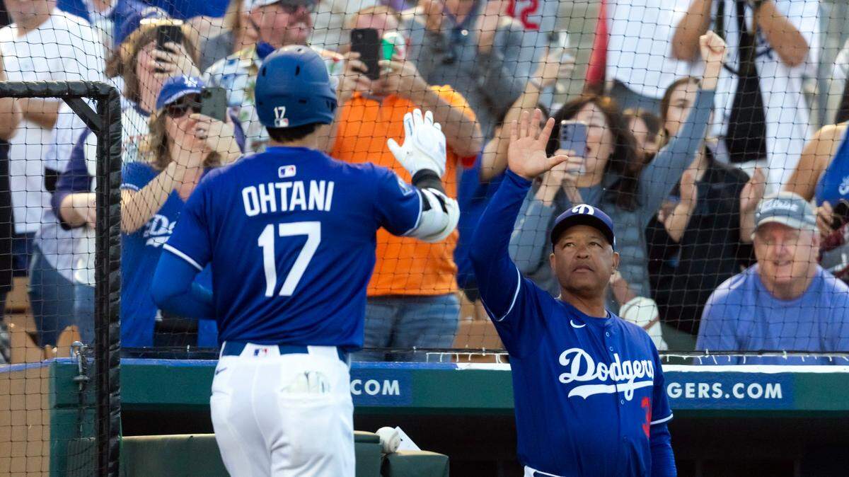 Los Dodgers de Los Angeles han otorgado una extensión a su entrenador Dave Roberts (der.) que le asegura mantenerse por cuatro temporadas más al frente del equipo campeón de las Grandes Ligas.