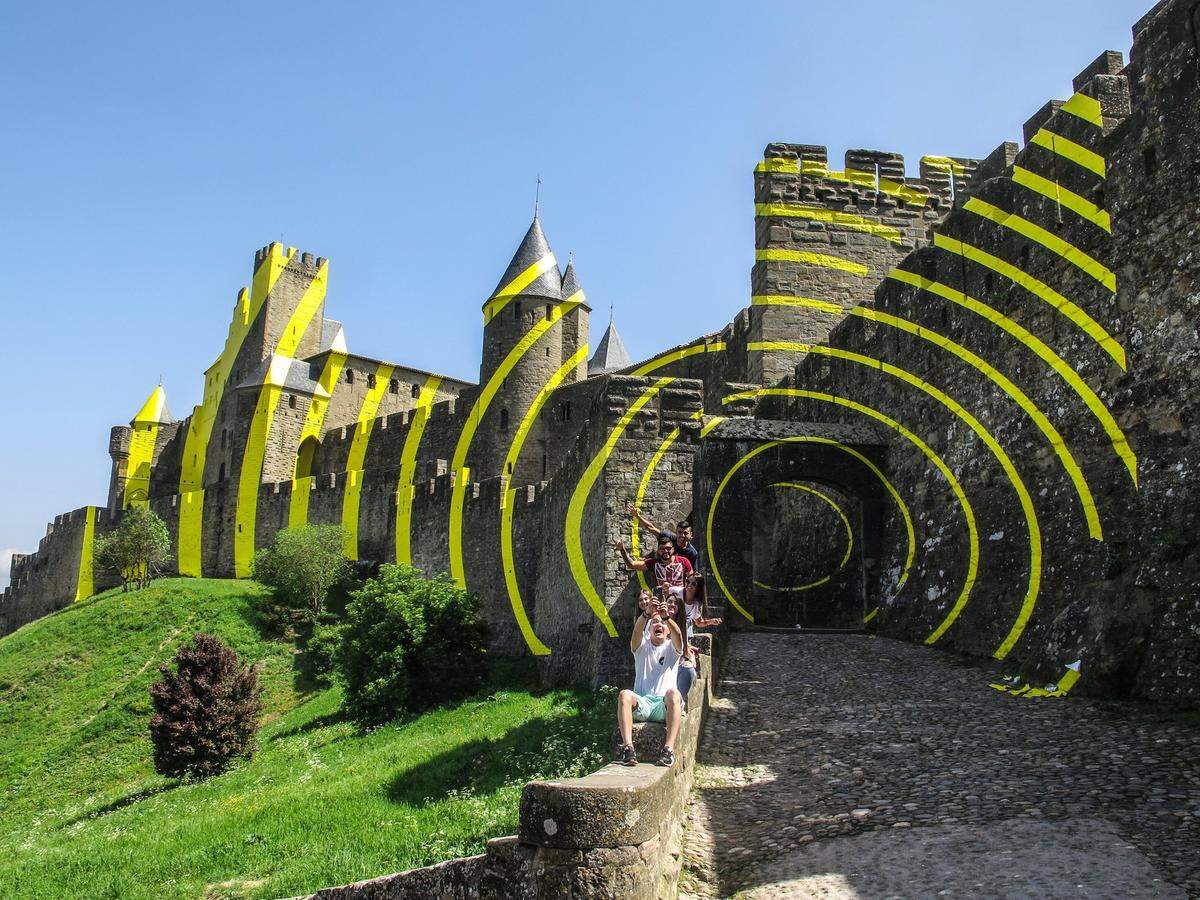 Vista del exterior del castillo medieval de Carcasona, decorado con círculos amarillos concéntricos por el artista suizo Felice Varini, en Francia.