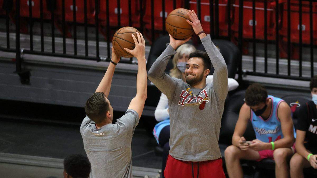 Max Strus (der.) tira al aro sobre su compañero de equipo Duncan Robinson, en una práctica del Heat previo al partido contra los Pacers de Indiana, el 21 de marzo de 2021 en Miami.