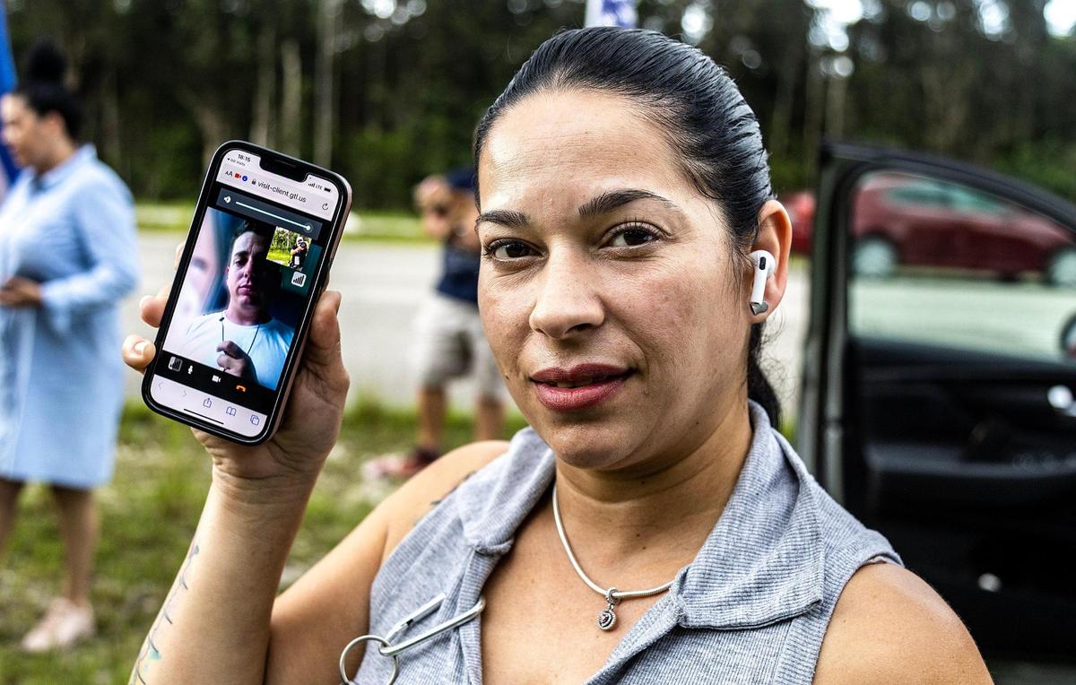Luis Alberto, detenido en Krome, hace una videollamada con su esposa Isdrey Borrero, mientras ella protesta junto a otros familiares de cubanos detenidos.