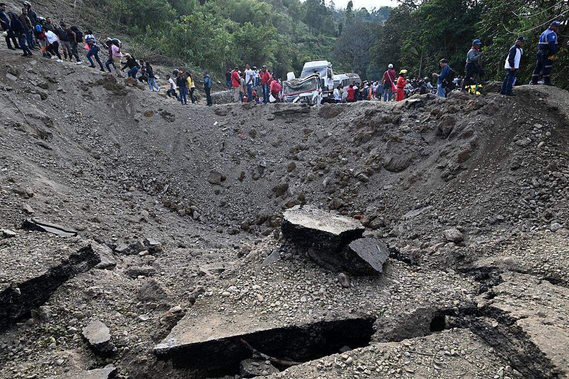 Personas caminan frente al lugar de una explosión tras un atentado con bomba en El Túnel, en la carretera Popayán-Cali, en Cajibío, departamento del Cauca, Colombia, el 25 de abril de 2026.
