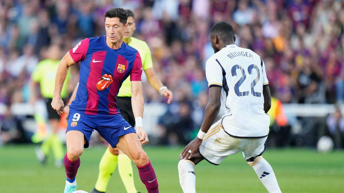 El delantero de Barcelona Robert Lewandowski (izq.) trata de pasar la marca de Rudiger, del Real Madrid, en el partido celebrado el 28 de octubre de 2024 en Barcelona.