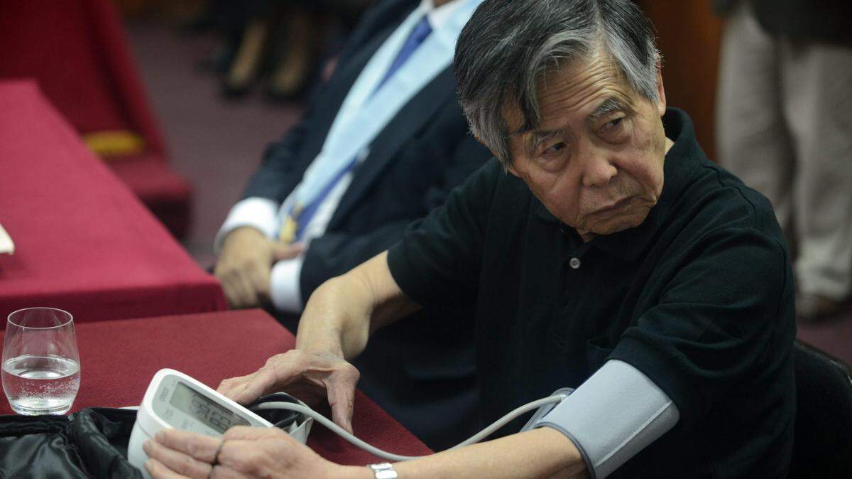 El expresidente peruano Alberto Fujimori (1990-2000), sentenciado a 25 años de cárcel por violación de derechos humanos, mide su presión arterial durante una audiencia pública, el viernes 25 de octubre de 2013, en la sala de juicios del cuartel policial de Lima.