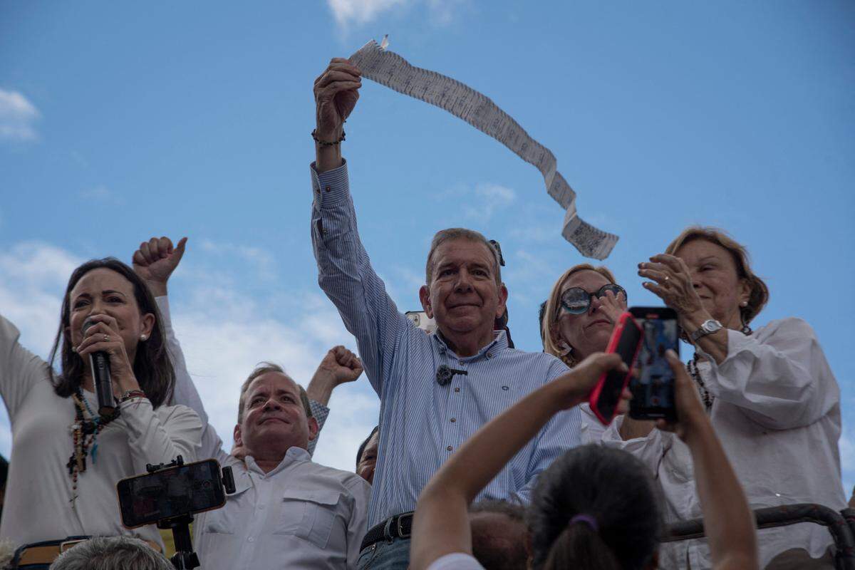 Foto de archivo. El candidato presidencial opositor venezolano Edmundo González (centro) muestra una copia de un acta electoral mientras la líder opositora María Corina Machado (izq.) da un discurso, durante una protesta para denunciar el supuesto fraude en las elecciones presidenciales, el 30 de julio de 2024 en Caracas.
