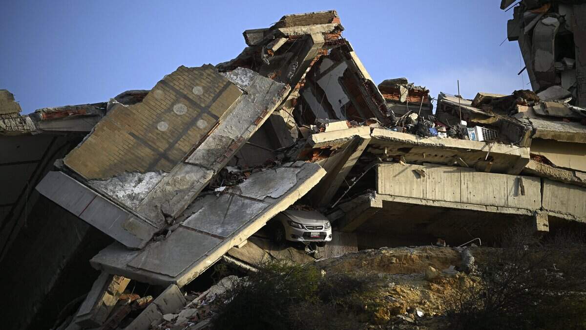 This view shows a collapsed concrete structure with crushed floors and debris, with a car partially buried beneath, in the Playa Verde sector of Catia La Mar, La Guaira state, Venezuela, on June 29, 2026, following twin earthquakes. Hopes were fading of finding survivors more than four days after powerful twin earthquakes struck Venezuela, as residents grow increasingly frustrated with the government's response to the disaster that has killed -up to now- more than 1,700 people and left tens of thousands unaccounted for. (Photo by Federico PARRA / AFP via Getty Images)