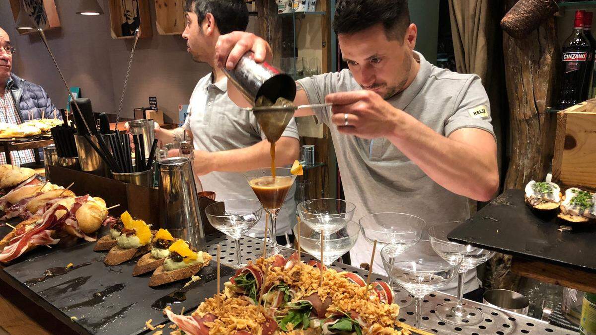 El turismo sigue creciendo en España y aumenta el optimismo del crecimiento económico. En la foto de archivo, un barman prepara una bebida junto a unos platos de pinchos en una taberna en San Sebastián, España. 