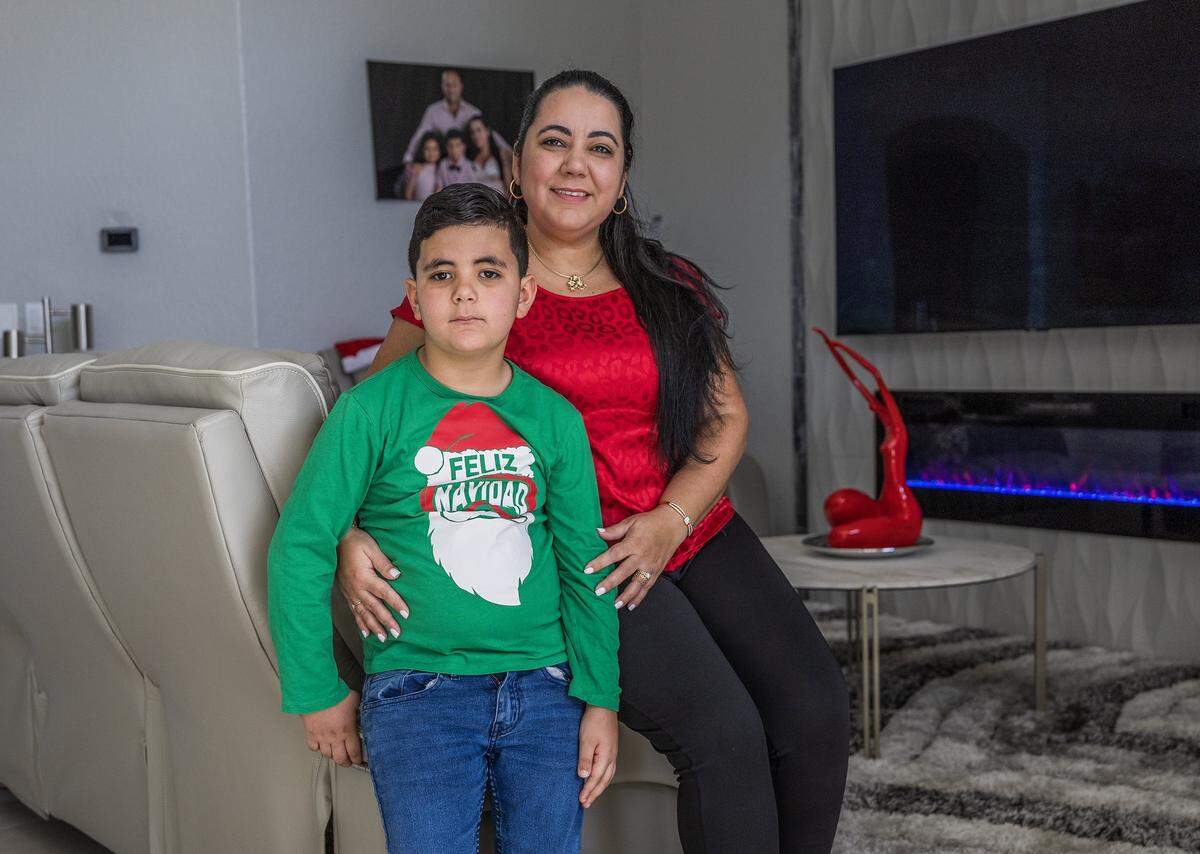 Yisel Herrera and her son Kaleb Oliva, 7 y.o, who was diagnosed with a tumor in the optic nerve, posed at home in Miami, Florida, on Wednesday, December 24, 2025. 