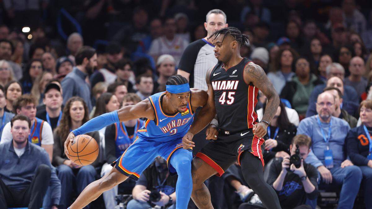El jugador del Thunder Shai Gilgeous-Alexander (izq.) trata de pasar la marca de Davion Mitchell, del Heat de Miami, en el partido celebrado el 12 de febrero de 2025 en Oklahoma City.