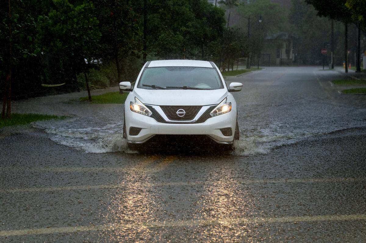 Un automóvil cruza la carretera inundada causada por las fuertes lluvias en North Bay Rd y 179th Dr. en Sunny Isles Beach el martes 11 de junio de 2024 en Florida.