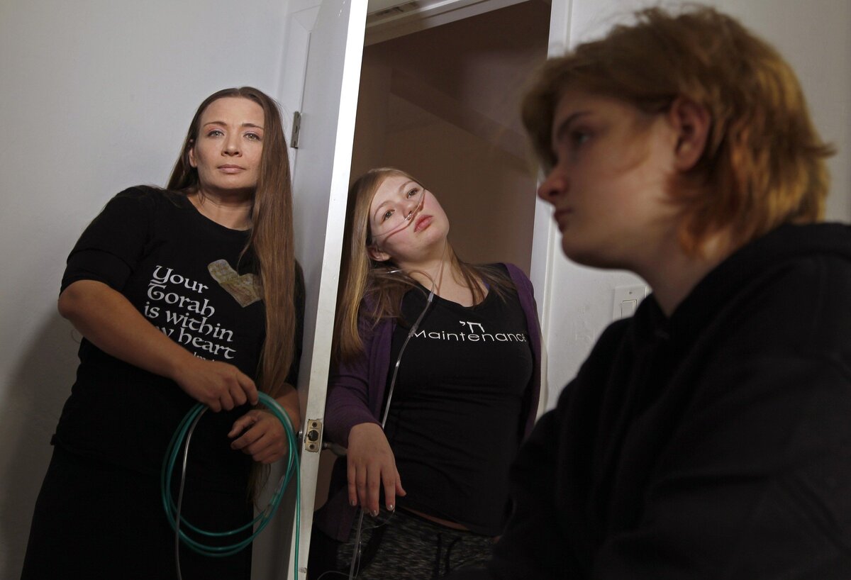 Rebekah Lewis, 17, is connected to an oxygen machine and rarely gets to leave the house because her family can’t afford a motorized scooter or a portable oxygen machine. Left to right: mother Tzedakah Cohen, Rebekah Lewis, 17, center, and Anna Lewis, 13.