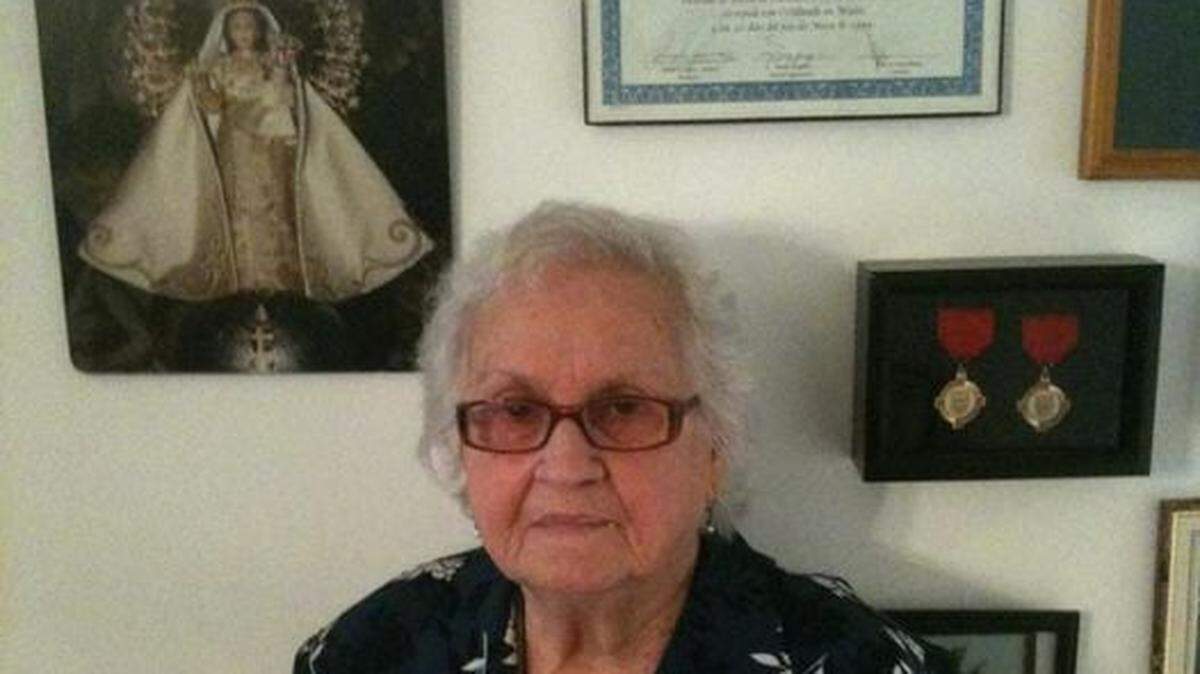 Georgina Nieto, in 2012 in her apartment in Miramar, Florida, poses next to a painting with the image of the Virgin of Charity.