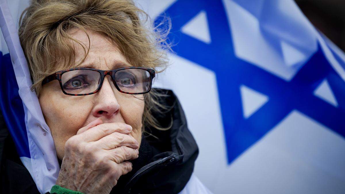 Una mujer responde a las imágenes mostradas del ataque a Hamás. Familiares de rehenes israelíes y ex rehenes secuestrados por Hamás están presentes durante una manifestación frente a la Corte Penal Internacional.