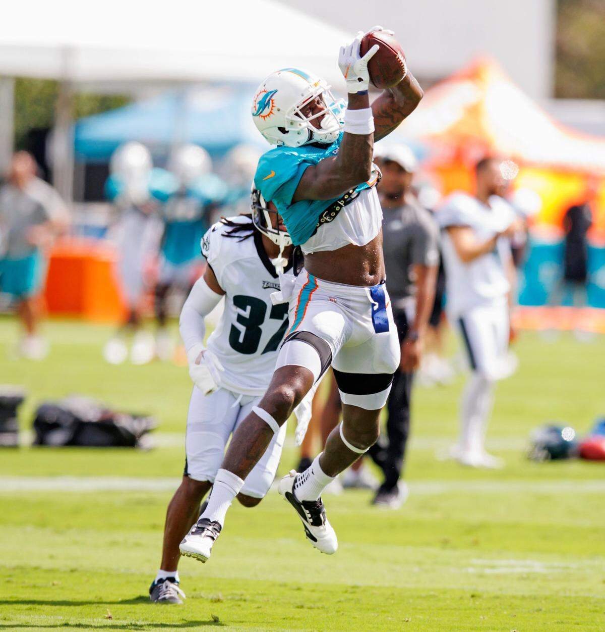 El wide receiver de los Dolphins Mohamed Sanu Sr. (16) atrapa un pase ante la defensa del cornerback de los Eagles de Filadelfia Mac McCain III, durante una práctica conjunta celebrada el 24 de agosto de 2022 en el Baptist Health Training Complex, en el Hard Rock Stadium de Miami Gardens, Florida.