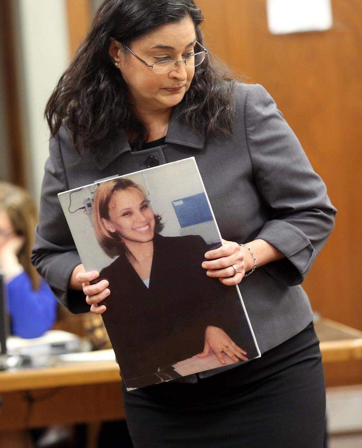 La fiscal Deisy Hernández sostiene una fotografía de la camarera asesinada, Yvette Fariñas, durante la fase de la pena de muerte del juicio de Rafael Andrés, el 15 de diciembre de 2014.