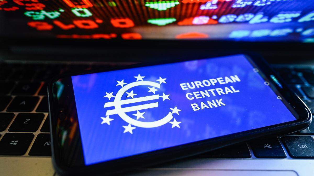 En esta ilustración fotográfica, se muestra un logotipo del Banco Central Europeo en un teléfono inteligente con porcentajes del mercado de valores en el fondo.
