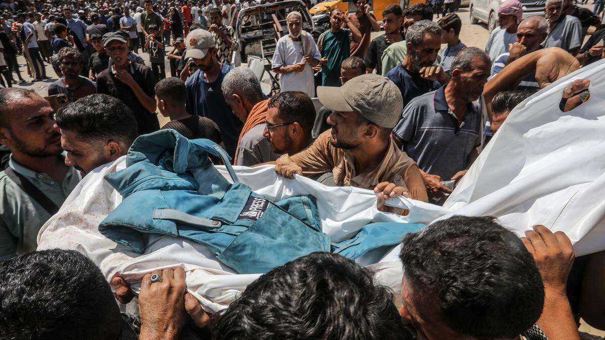 Varias personas cargan el cadáver de un periodista que murió en un bombardeo israelí al Hospital Nasser en Jan Yunis, en el sur de Gaza, el lunes 25 de agosto de 2025.