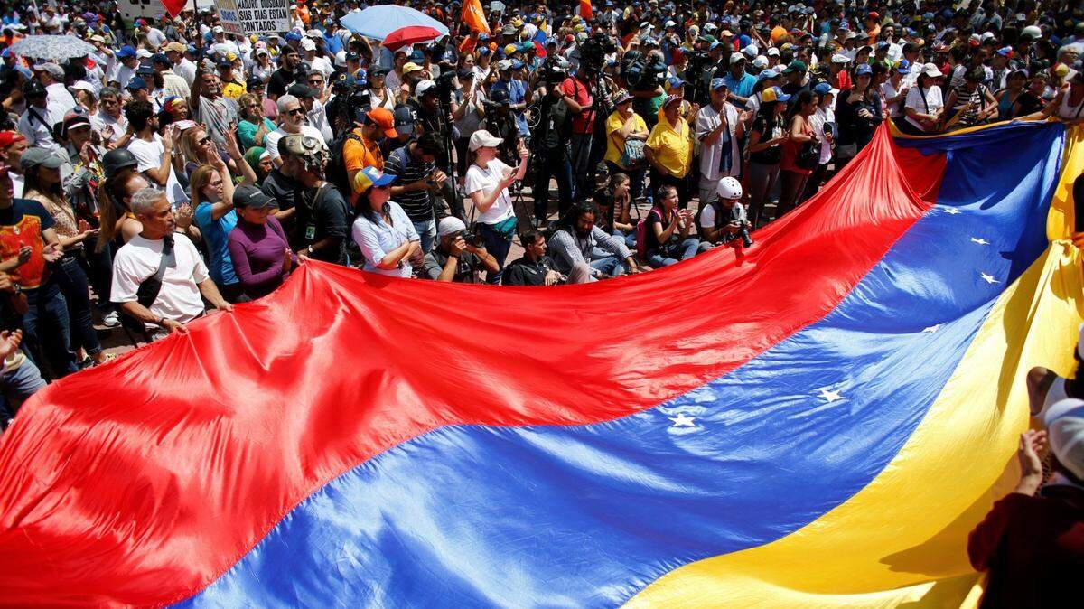 Anti-government demonstrators wave a Venezuelan flag during a protest against Venezuela’s President Nicolas Maduro in Caracas, Venezuela, Saturday, Aug. 12, 2017. Opposition members called a demonstration to protest the seating of a special assembly to rewrite the constitution. Observers will be closely watching the turnout as the arrest of several mayors and the opposition’s decision to compete in regional elections despite concerns the election for the constitutional assembly was marred by fraud. (AP Photo/Ariana Cubillos)