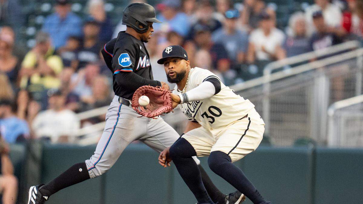 El torpedero de los Marlins Xavier Edwards regresa a la primera base custodiada por Carlos Santana, de los Mellizos, en el partido celebrado el 26 de septiembre de 2024 en Minneápolis, Minnesota.