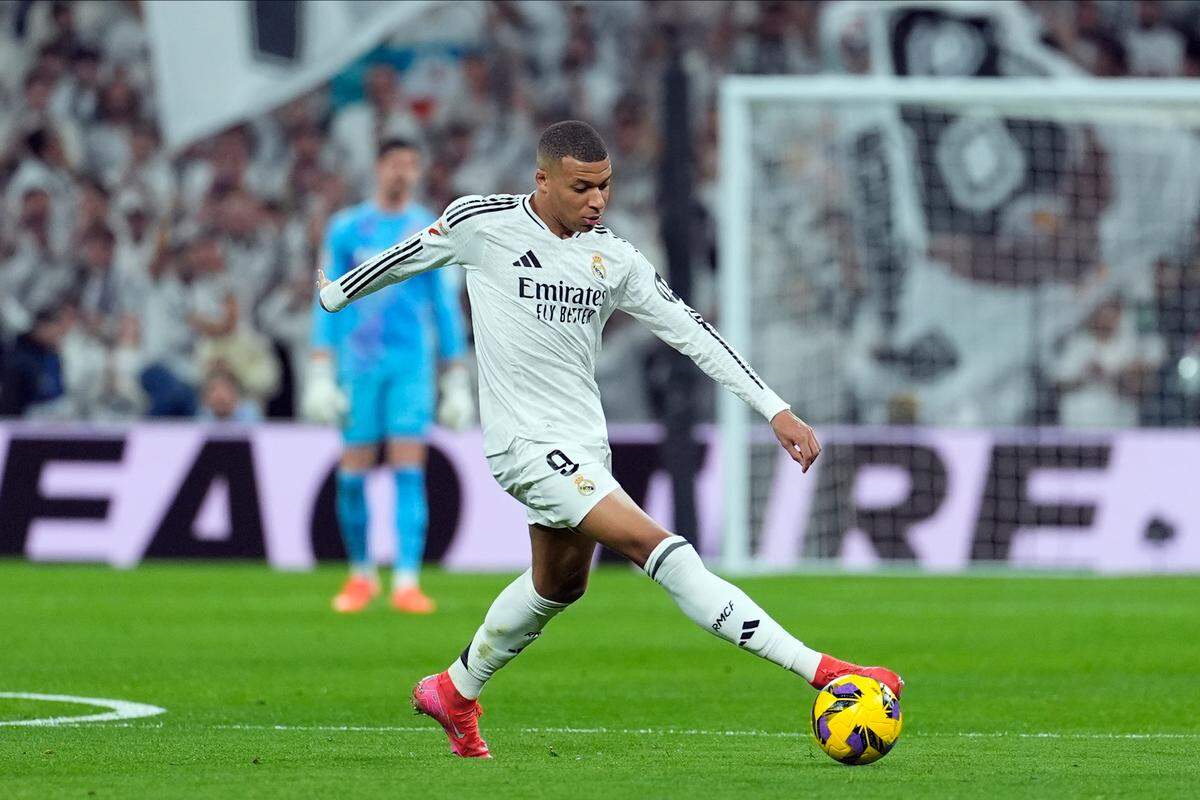 El jugador del Real Madrid Kylian Mbappé conduce el balón en el partido de la liga española ante el Atlético, celebrado el 8 de febrero de 2025 en Madrid.