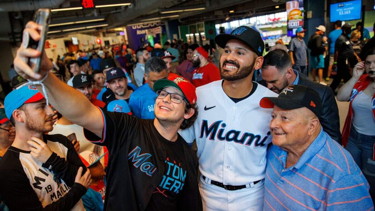 El pitcher venezolano de los Marlins Pablo López se toma una foto con Ethan Bernstein (izq.) y Peter García, antes del partido inaugural de la temporada en Miami contra los Filis de Filadelfia, el 14 de abril de 2022.