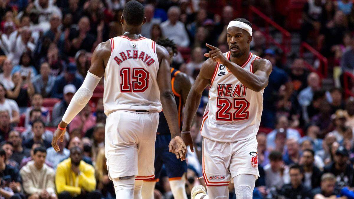El alero del Miami Heat, Jimmy Butler (22), apunta hacia el ex jugador del Heat, Dwyane Wade, luego de anotar sobre los New York Knicks durante la segunda mitad de un partido de la NBA en el Miami-Dade Arena Downtown Miami, Florida, el miércoles 22 de marzo de 2023.