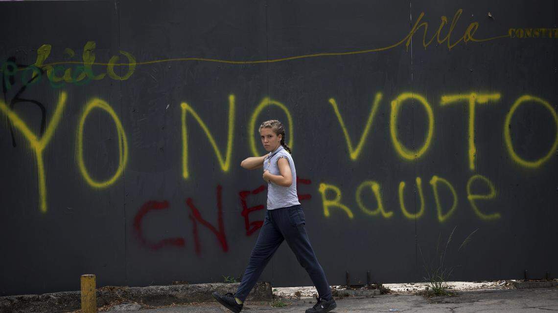 Una persona pasa junto a un grafiti en Caracas, Venezuela, el 20 de abril del 2018.