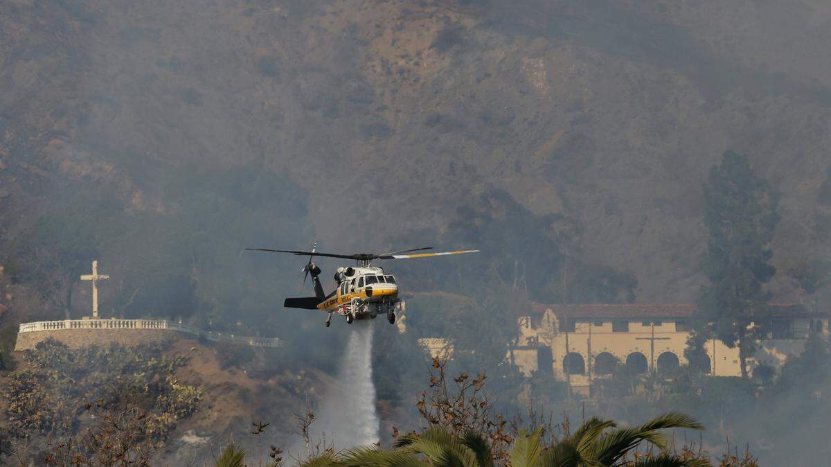 Un helicóptero de bomberos arroja agua sobre el incendio forestal en Malibú, California, Estados Unidos, el 10 de diciembre de 2024.
