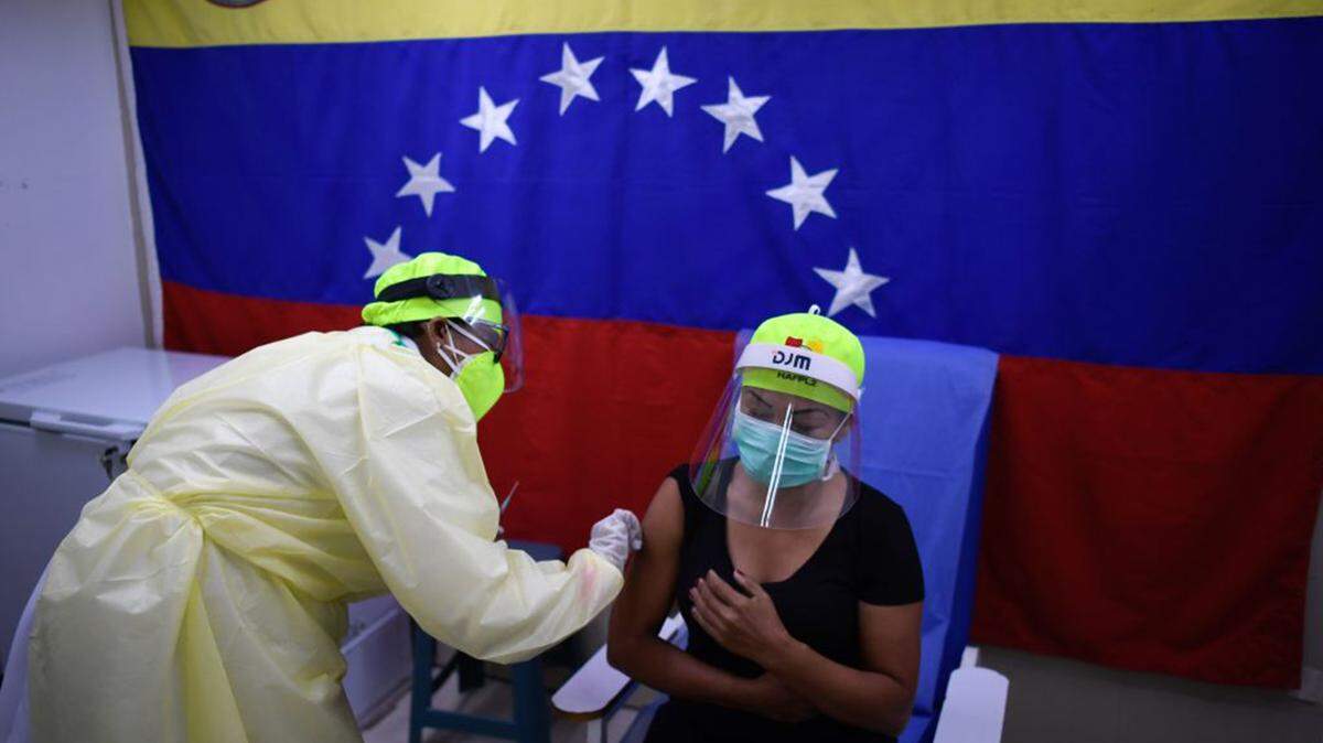 Un trabajador de salud administra una dosis de la vacuna rusa Sputnik V contra COVID-19 a un miembro del personal del Hospital Ana Francisca Pérez de León en el barrio de Petare, en el este de Caracas, el 19 de febrero de 2021.
