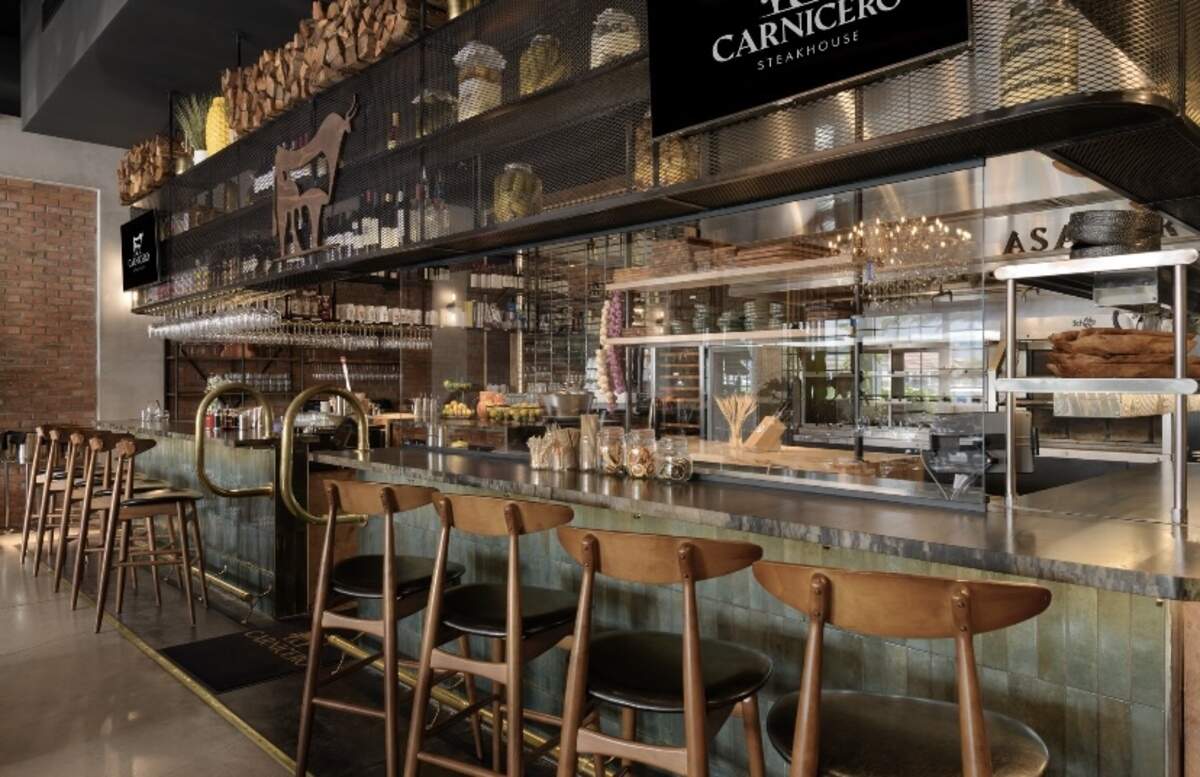 Resulta agradable a la vista la barra de bebidas, que detrás tiene los fogones donde se asa la carne.