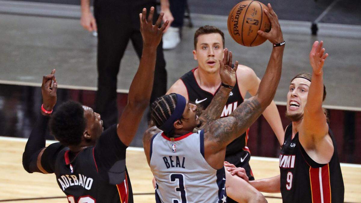 El base de los Washington Wizards, Bradley Beal (3), intenta anotar mientras el alero del Miami Heat, Kelly Olynyk (9), defiende en el primer cuarto en el AmericanAirlines Arena en Miami el viernes 5 de febrero de 2021.