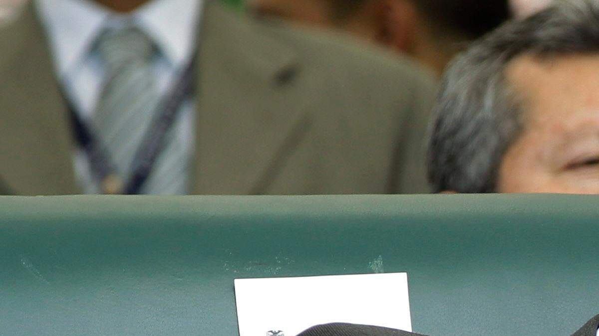 El presidente colombiano Juan Manuel Santos y el ex mandatario Álvaro Uribe conversan durante la ceremonia de juramentación del Santos, el 6 de agosto de 2010 en Bogotá. 