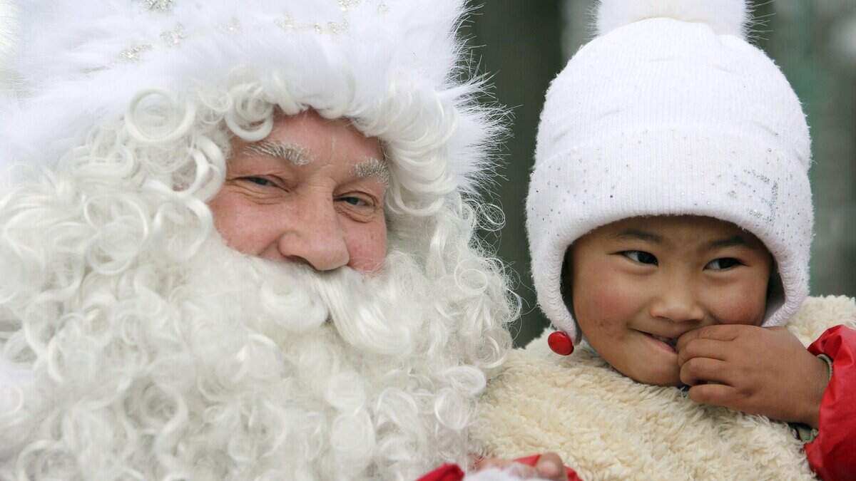 “Abuelo Frío” o “Abuelo Hielo” (izq) conversando con una niña en un parque de Biskek (Kirguizistán). Esta figura es el equivalente de Papa Noel en la cultura eslava. EFE / Igor Kovalenko