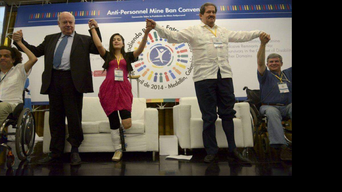 El Secretario General de la Organización de Estados Americanos (OEA), José Miguel Insulza (2-i), el vicepresidente de Colombia, Angelino Garzón (2-d) y la colombiana Ángela Ruales - víctima de una mina antipersonal - con los pantalones enrollados , participan en una actividad del programa "Dona tu pierna" la conciencia y la solidaridad (conocido como "Remangate" en español), durante una conferencia mundial sobre ayuda para las víctimas de guerra y sobrevivientes de minas antipersonales y otros restos explosivos en Medellín, departamento de Antioquia, Colombia, el 4 de abril de 2014. De acuerdo con las organizaciones gubernamentales y de derechos humanos, Colombia es el segundo país del mundo después de Afganistán, con el mayor número de víctimas de minas antipersonales.