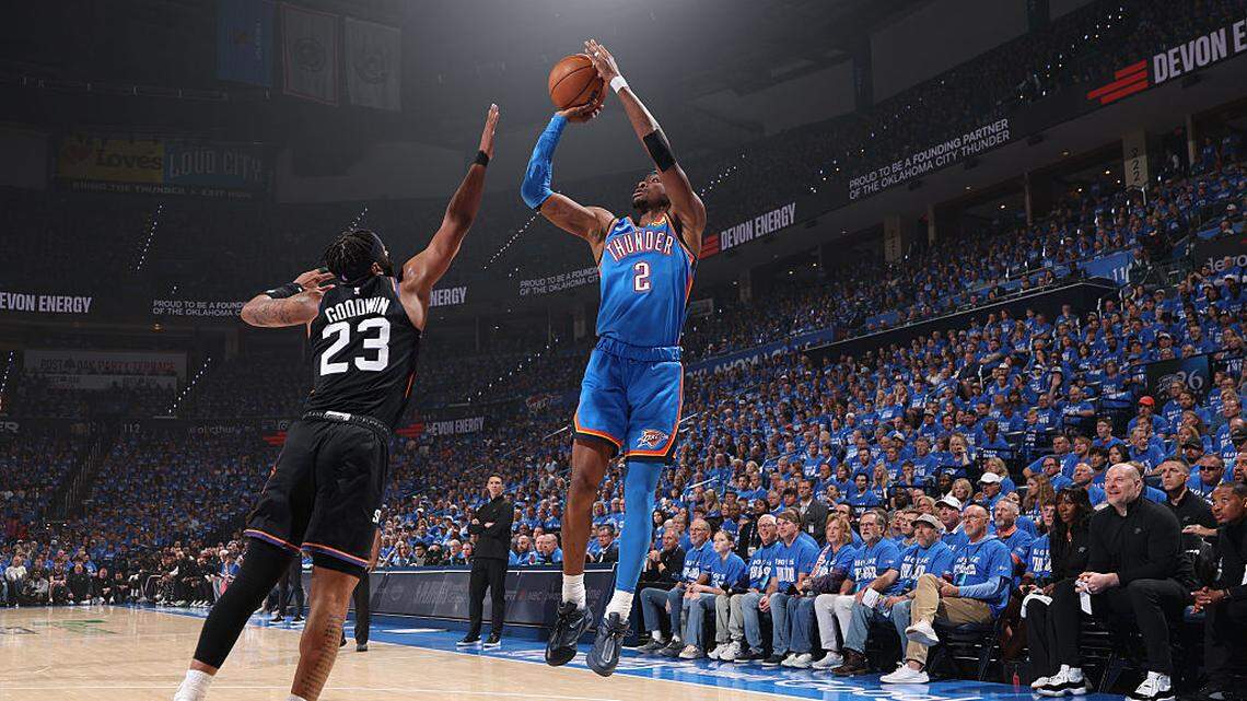 El astro del Thunder Shai Gilgeous-Alexander (der.) tira al aro ante la defensa de Jordan Goodwin, de los Suns de Phoenix, en el partido de la primera ronda de playoffs de la Conferencia Oeste, celebrado el 19 de abril de 2026 en Oklahoma City, Oklahoma. 