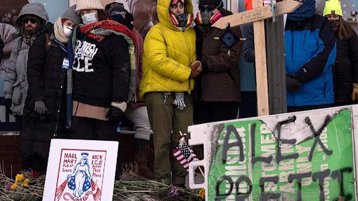 Varias personas guardan luto en un monumento improvisado en el lugar donde Alex Pretti, de 37 años, fue asesinado a tiros por agentes federales de inmigración ese mismo día en Minneapolis, Minnesota, el 24 de enero de 2026.