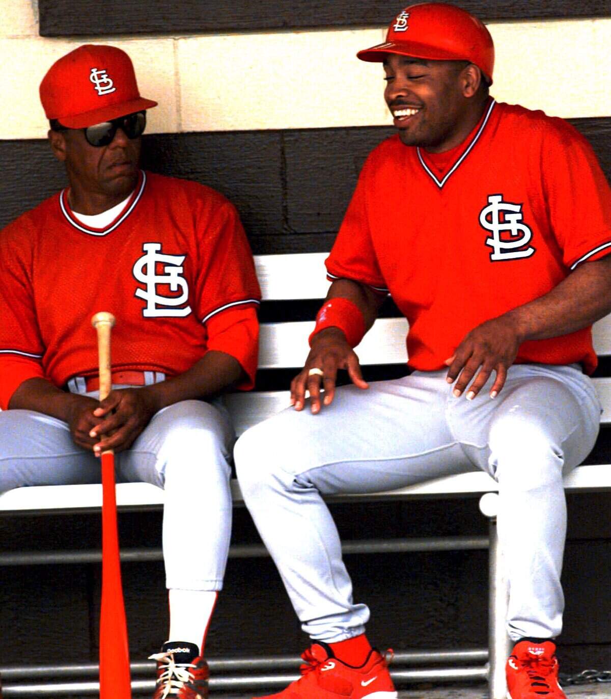 El jardinero de los Cardenales de San Luis Ray Lankford (der.) bromea con José Cardenal en el dugout en el entrenamiento de primavera, el 6 de abril de 1995 en St. Petersburg, Florida.