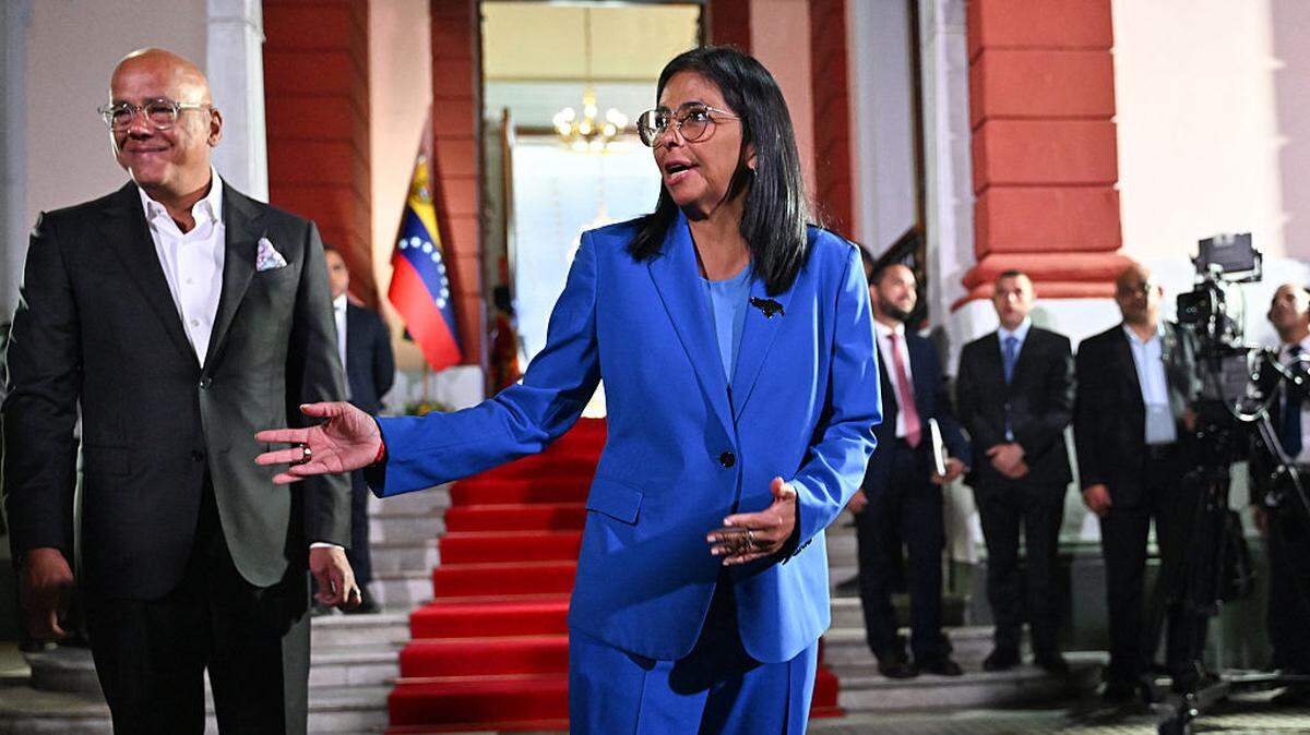 La presidenta interina de Venezuela, Delcy Rodríguez, hace un gesto junto a su hermano, el presidente de la Asamblea Nacional, Jorge Rodríguez (izq.), después de firmar la ley de amnistía en el Palacio de Miraflores en Caracas, el 19 de febrero de 2026.