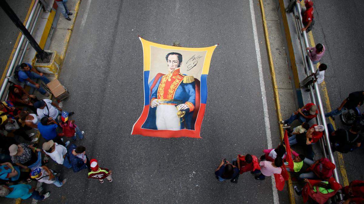 Seguidores del gobernante Nicolás Maduro sostienen una bandera con la imagen del héroe de la Independencia de Venezuela, Simón Bolívar, durante una marcha el 12 de septiembre de 2019 en Caracas.