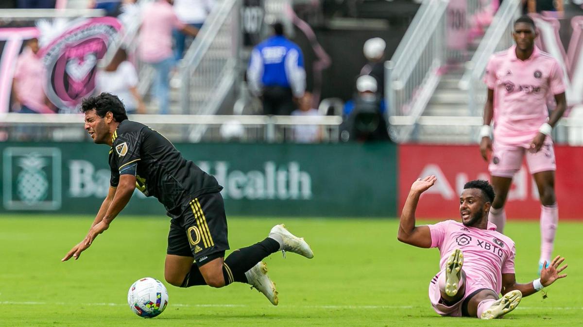 El mediocampista de Inter Miami Mo Adams (6) se desliza por el balón contra el delantero de Los Angeles FC Carlos Vela (10) durante la primera mitad de su partido de fútbol de la MLS en el estadio DRV PNK el sábado, 12 de marzo de 2022, en Fort Lauderdale, Florida.