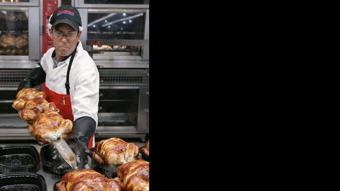 UN EMPLEADO de Costco en Mountain View, California, saca unos pollos asados del horno.