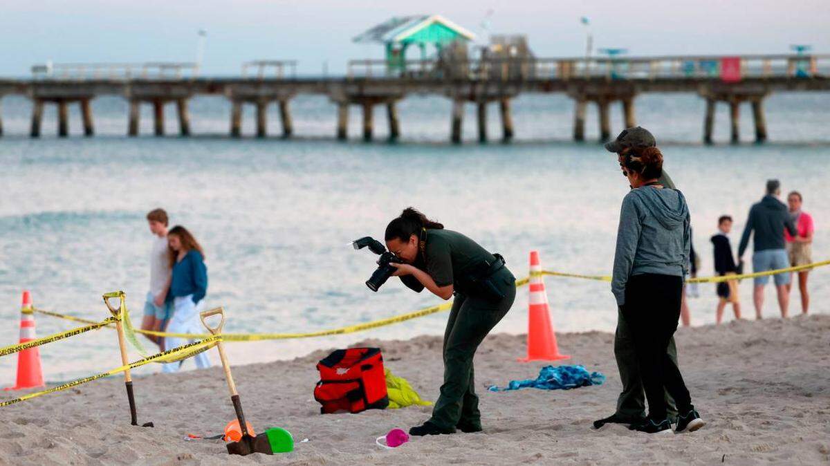 Investigadores en la playa de Lauderdale-by-the-Sea toman fotografías de la escena de un colapso de arena el martes 20 de febrero de 2024.  MIKE STOCKER South Florida Sun Sentinel